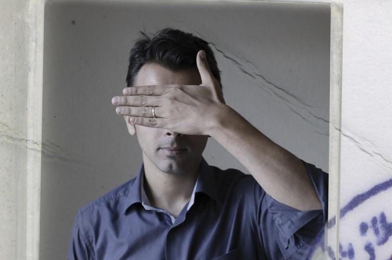 Image of a man with hand over his face